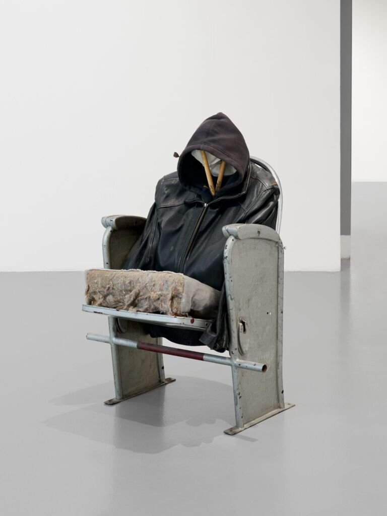Un siège métallique sur lequel est posé une veste en cuir dans une salle d