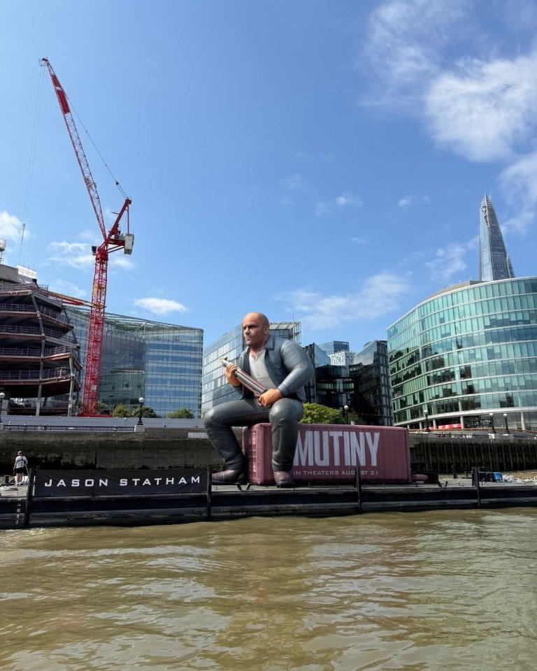 Le ballon géant Jason Statham remorqué sur la Tamise devant les tours de la City