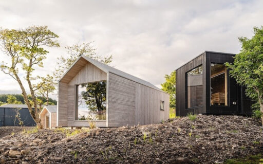 Des cabanes en bois à toit pointu s'intègrent aux reliefs écossais
