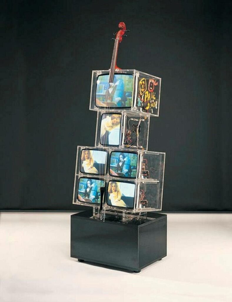 Installation artistique représentant six télévisions cathodiques empilées les unes sur les autres et recouvertes par les cordes d